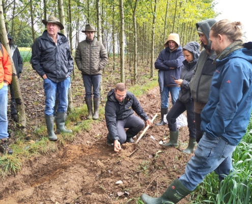 Moritz Böhm, Bioland e.V. (mit Spaten), bespricht die Ackerbewirtschaftung zwischen den Gehölzstreifen